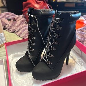 NIB JustFab black faux leather 6” high heel combat boot.